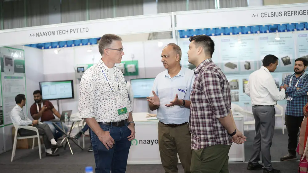 Delegates talking beside a refrigeration and automation stand