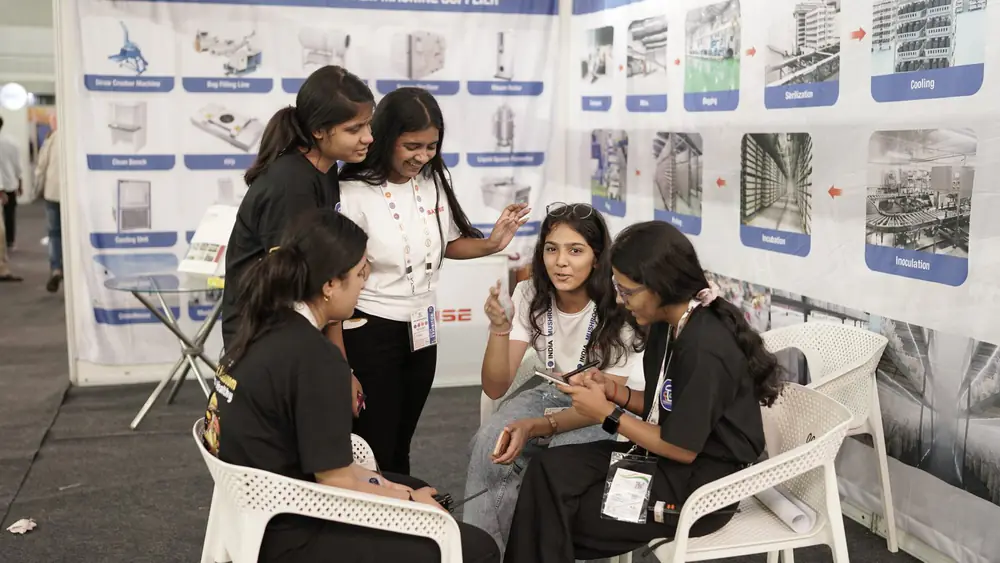 Students at an exhibitor stand reading product material